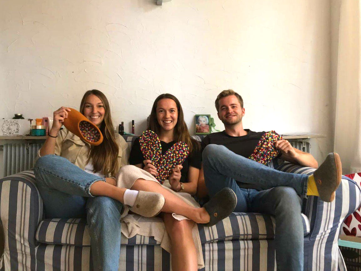 Three adults wearing slippers fitted with WoolFit FeelGood footbeds